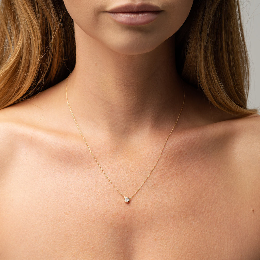 Picture of diamond necklace on model. 9ct  yellow gold bezel set round diamond necklace with yellow gold chain. This beautiful necklace can be made with a lab grown or natural diamond. Custom made engagement rings and fine jewellery Sunshine Coast, Buderim. Australian made necklaces. 