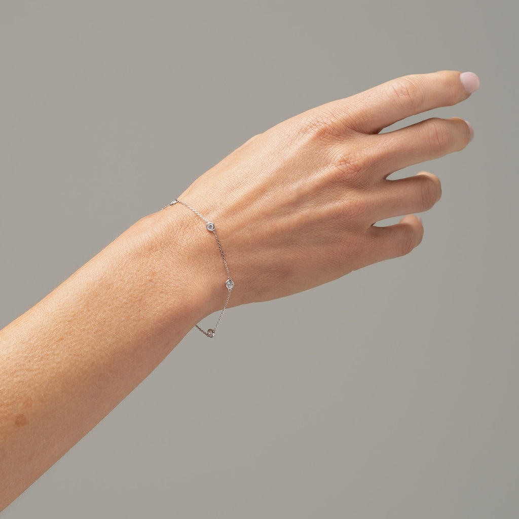 picture of bracelet on model's wrist white gold delicate bracelet with bezel set cubic zirconias