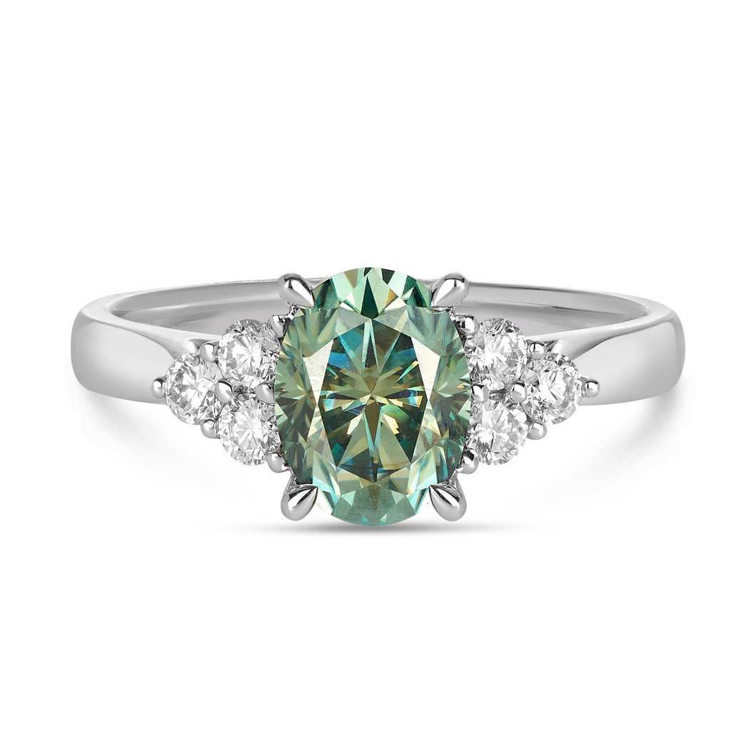 This vintage inspired engagement ring features an oval cut teal Seafoam Moissanite stone with three round cluster set diamonds on the shank. The perfect coloured gemstone for your engagement ring or dress ring Sunshine Coast jewellery