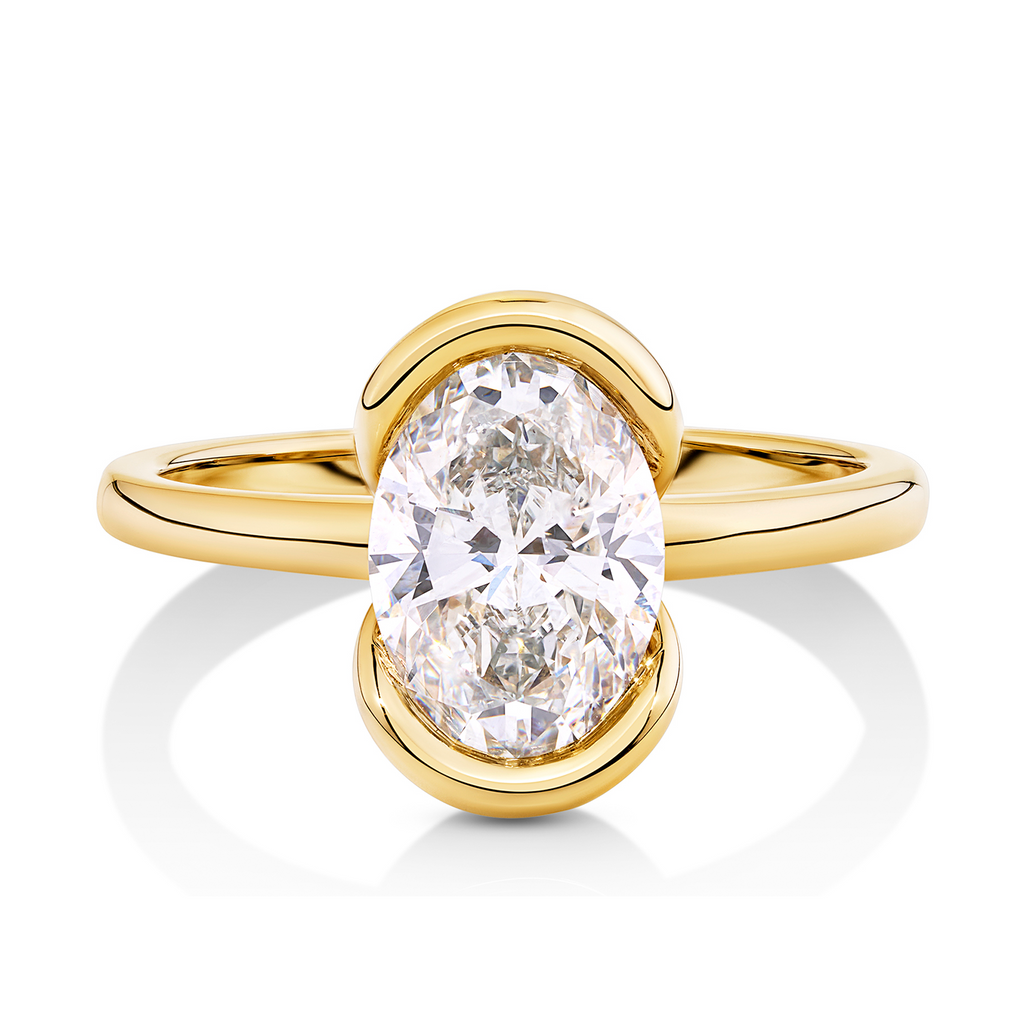 14ct yellow gold modern engagement ring sunshine coast with an oval cut diamond in a half bezel setting. unique and modern engagement ring sunshine coast